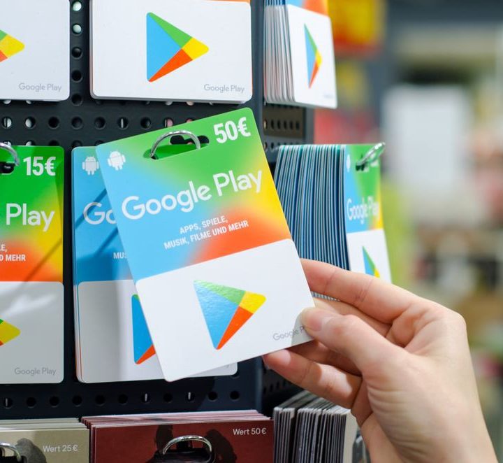 A hand reaching or a Google Play gift card on a shelf.