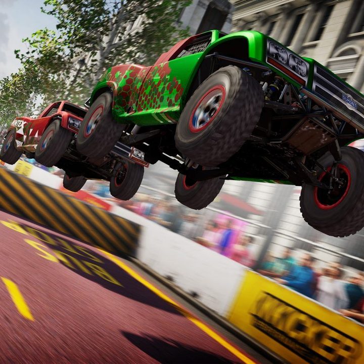 Cars race down a street in Grid Legends.
