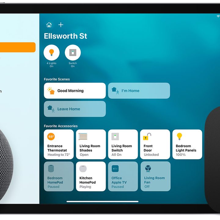 A HomePod mini and Apple TV device in front of an iPad with the Home app displayed.