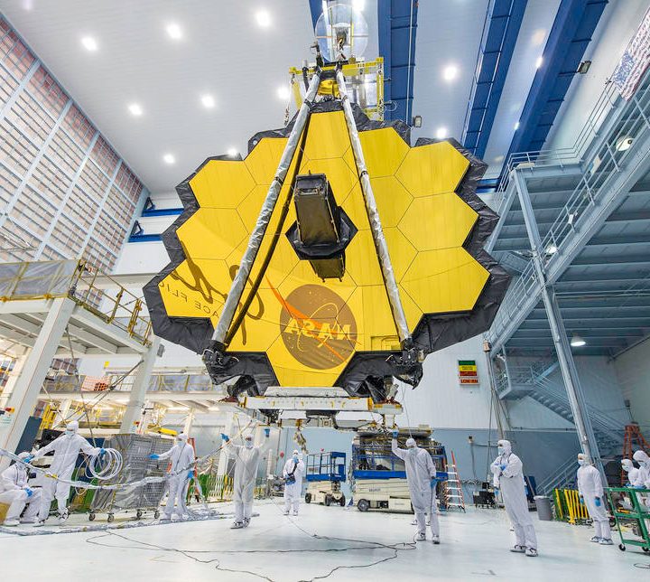 NASA technicians lift the James Webb Telescope, using a crane, and move it inside a clean room at NASA’s Goddard Space Flight Center in Greenbelt, Maryland.