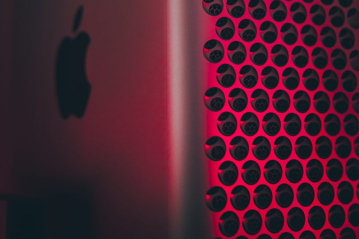 A close-up of a Mac Pro lit in red.