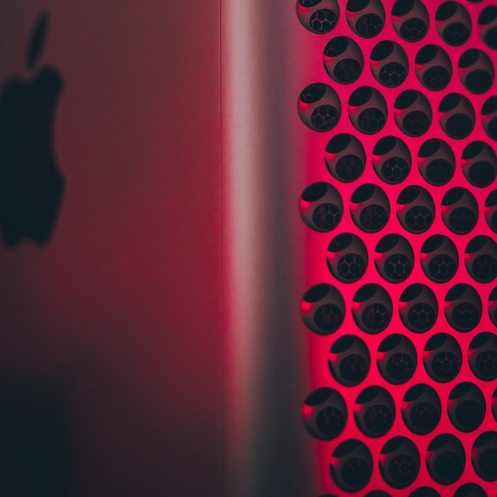 A close-up of a Mac Pro lit in red.