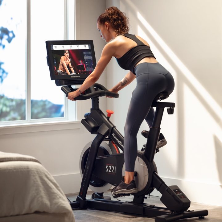 Woman riding a NordicTrack Commercial S221 Studio Cycle.