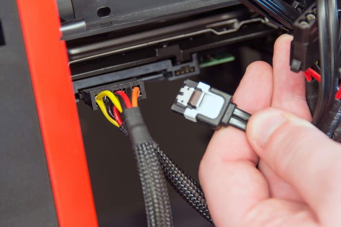 Plugging a SATA cable into a hard drive.