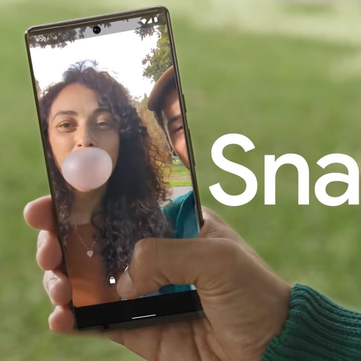 Hand holding Google Pixel phone with a picture of a woman blowing a bubble.