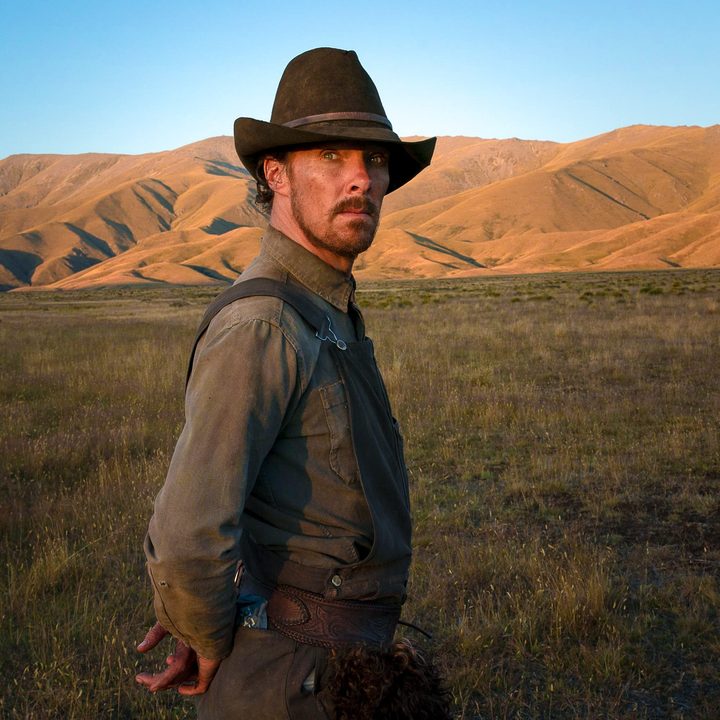 Phil Burbank standing in an open field in the Power of the Dog.