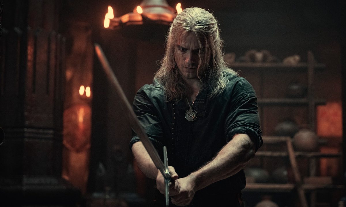 Henry Cavill holds a sword as Geralt of Rivia in The Witcher.