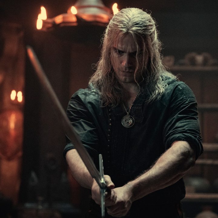 Henry Cavill holds a sword as Geralt of Rivia in The Witcher.