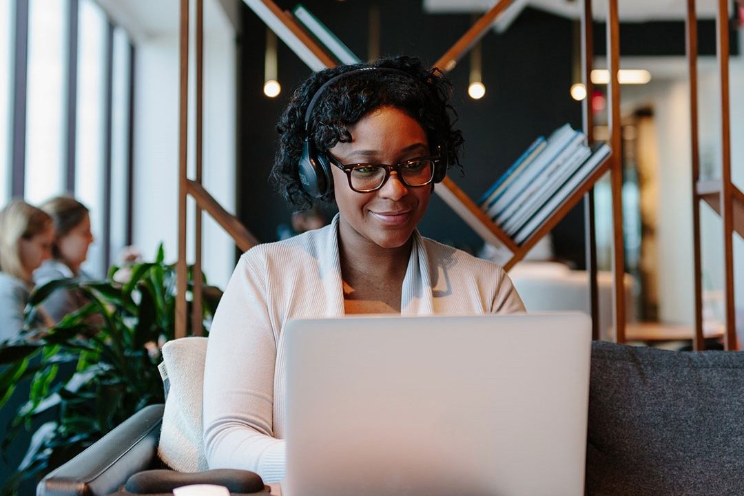woman working in shared Industrious workspace with laptop.