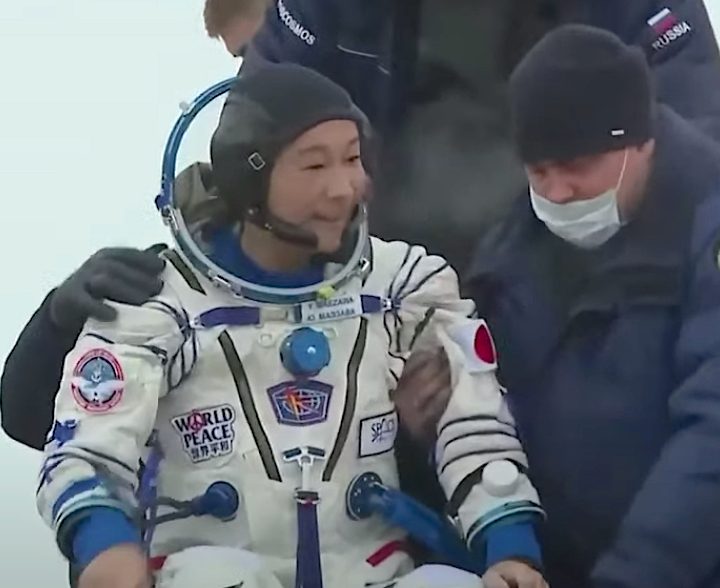 Yusaku MAezawa emerging from a Soyuz spacecraft.