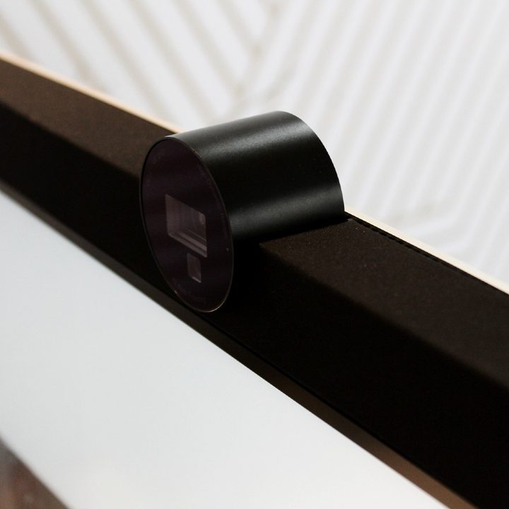 The 4K webcam resting in the cradle of the monitor's bezel.