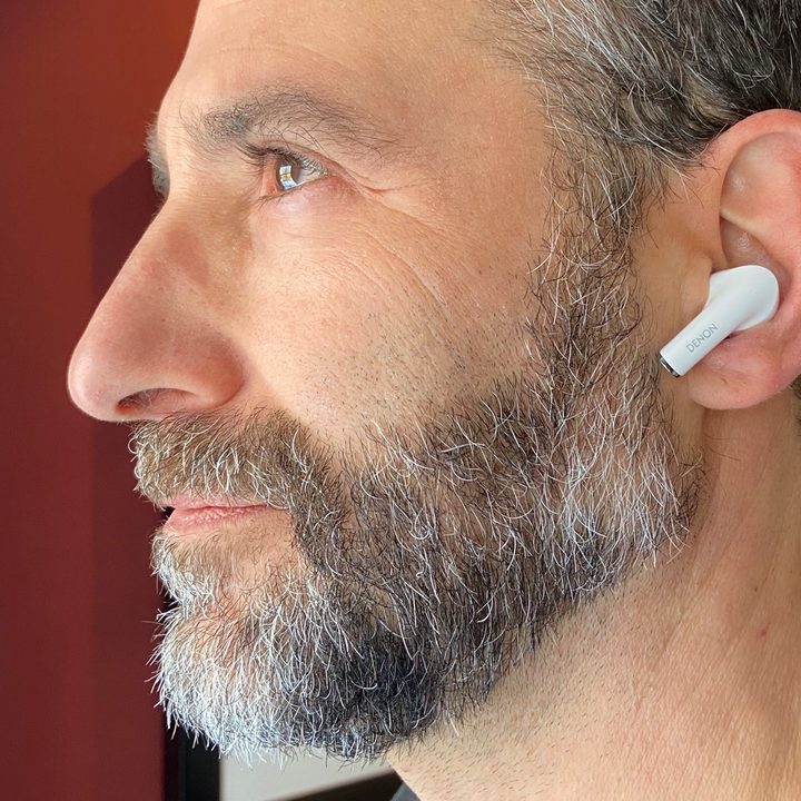 Man wearing Denon Noise Cancelling Earbuds AH-C830NCW.