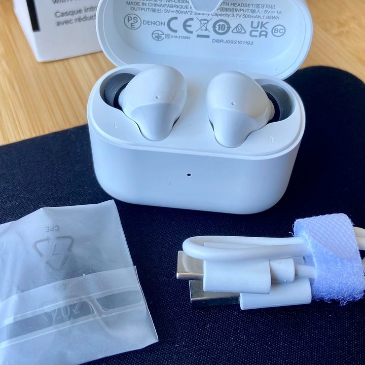 Denon Noise Cancelling Earbuds AH-C830NCW come with a charging case, eartips, and an adapter..