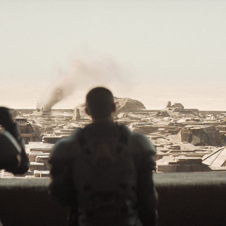 Characters from Dune look out over the landscape of Arrakis.
