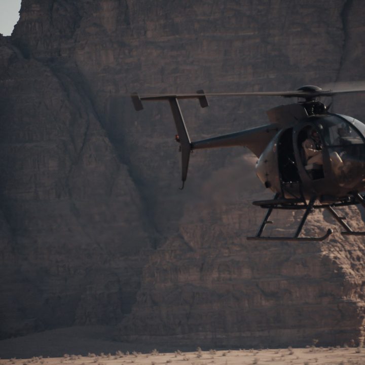 A helicopter flying over sand dunes while filming Dune.