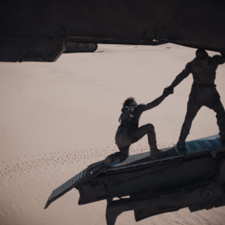 Characters from Dune look down at the sand in an early VFX scene from Dune.