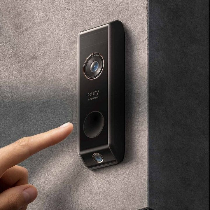 Finger pressing the Eufy Security Video Doorbell Dual.