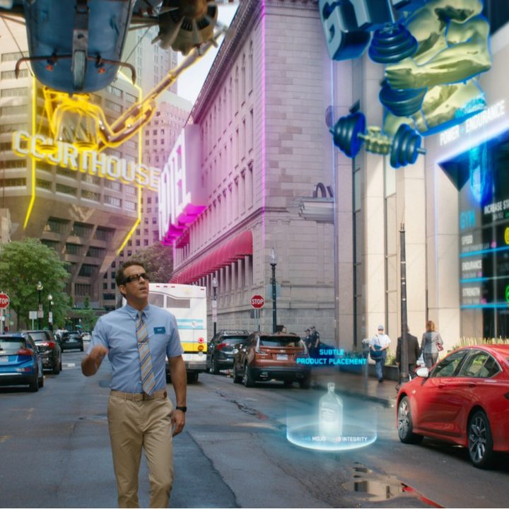 Ryan Reynolds runs down a busy street in a scene from Free Guy.