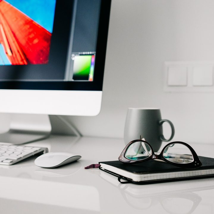 iMac on a desk with glasses and a notebook from Pixabay.