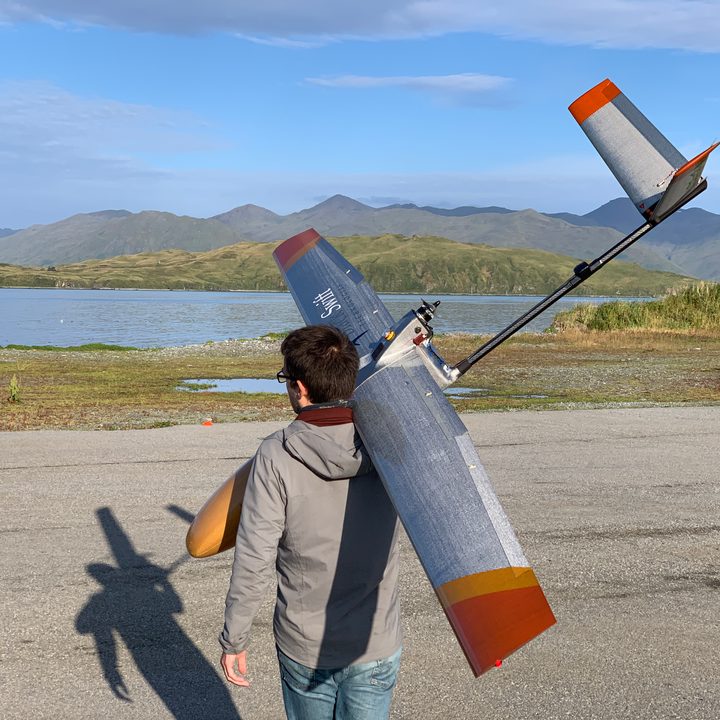 Maciej Stachura of Black Swift Technologies carries the S2 aircraft to its launch site at Dutch Harbor airport in Alaska.