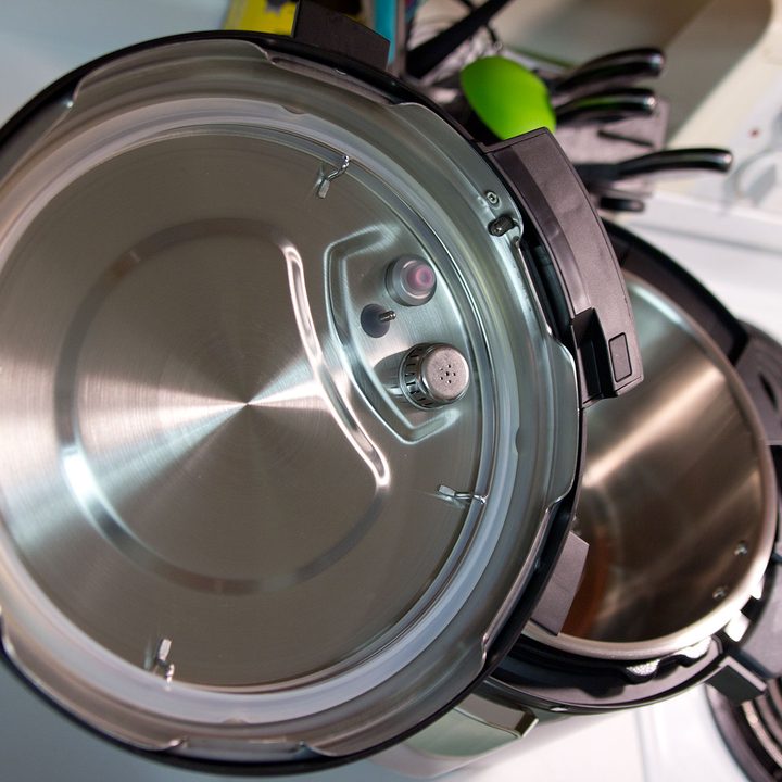 Instant Pot Pro Plus lid held in kitchen.