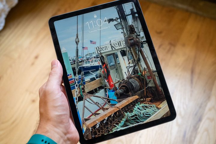 A man holding the 2022 Apple iPad Air.