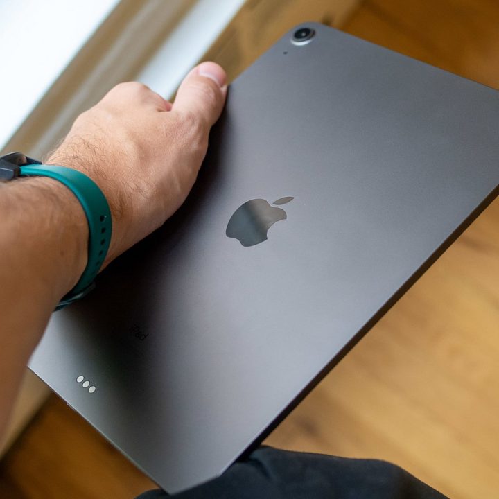 A person's arm holding an Apple iPad Air 2020.