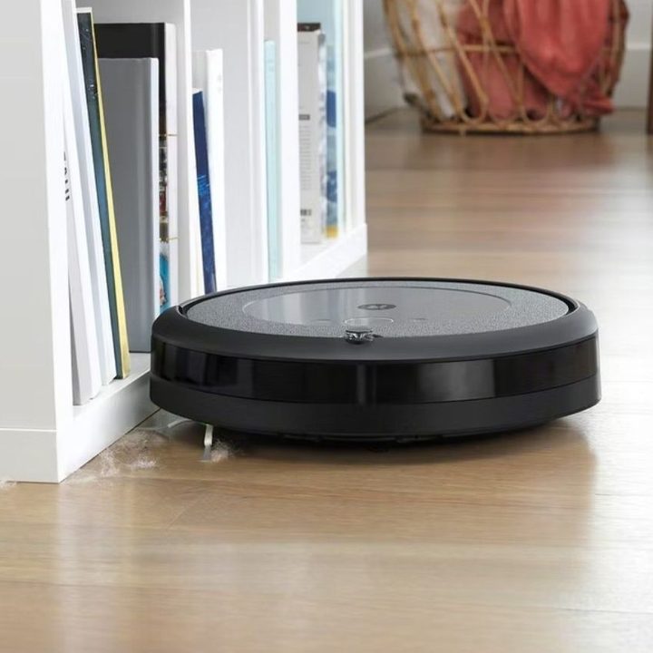 iRobot Roomba i3 Plus cleaning a wooden floor.