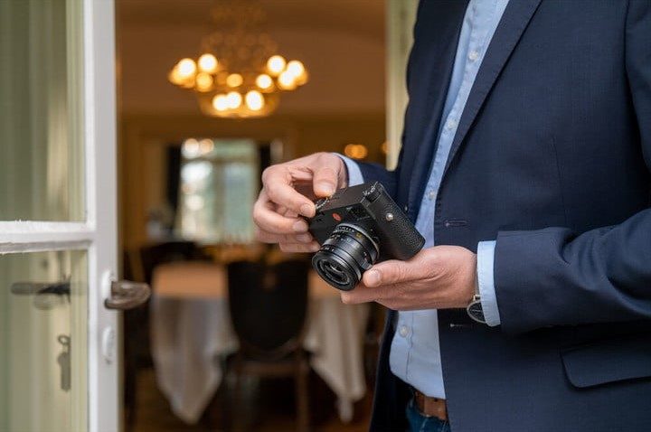 A man inspects a Leica camera.