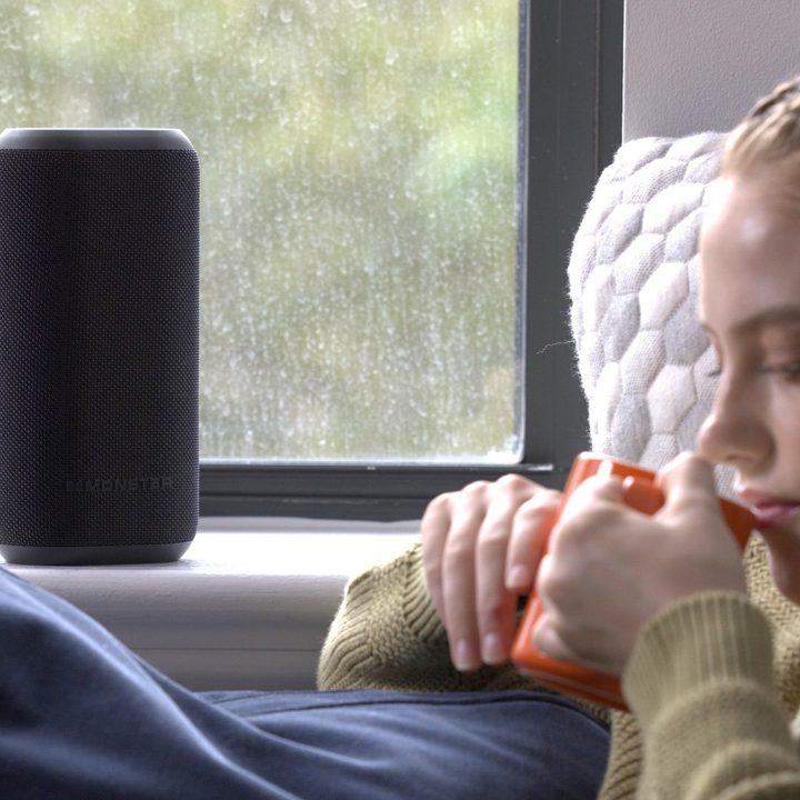 A woman relaxes while listening to the Monster DNA Max speaker.
