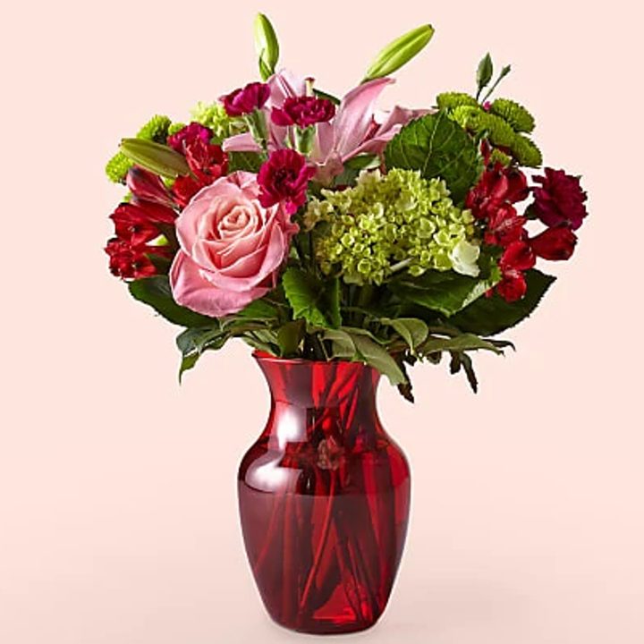 Pro Flowers Love Me Bouquet in a red glass vase.