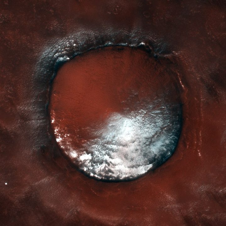The contrasting colors of bright white water-ice against the rusty red Martian soil.