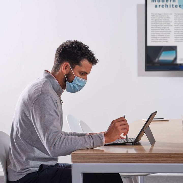 A man works on a Windows tablet.