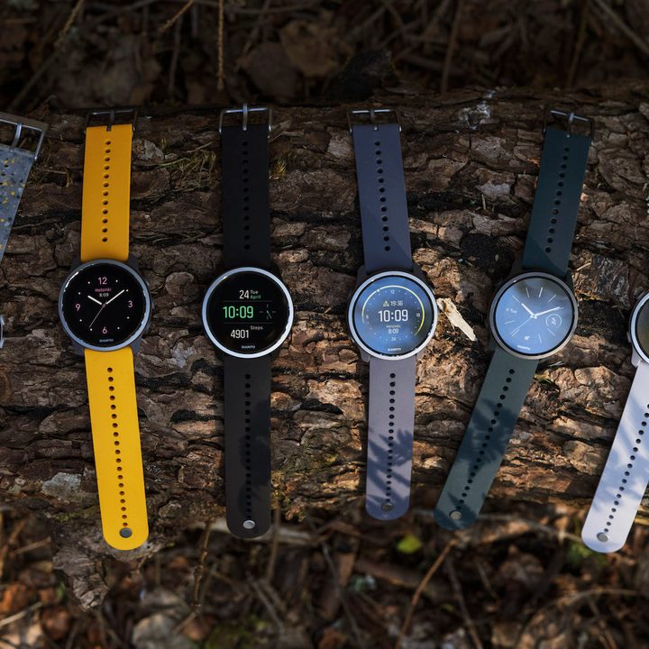 Various colors of Suunto 5 Peak GPS watch on a log.