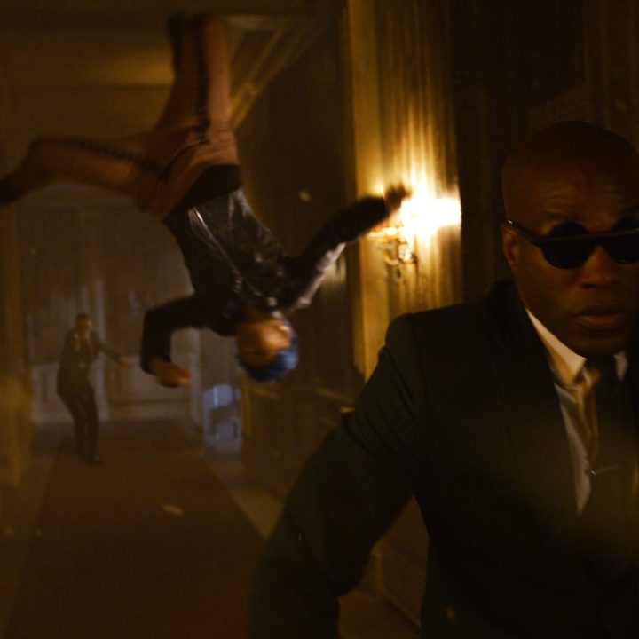 Jessica Henwick and Yahya Abdul-Mateen II race down a hallway in a scene from The Matrix Resurrections.