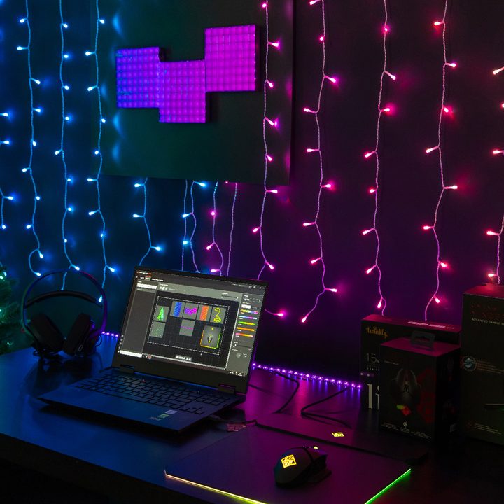 Twinkly Dots LED string lights set up on a wall behind a laptop.