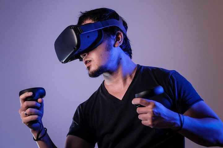 A man using a virtual reality headset with controllers.