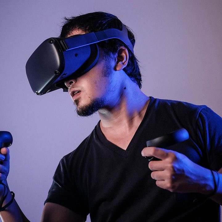 A man uses a virtual reality headset with controllers.