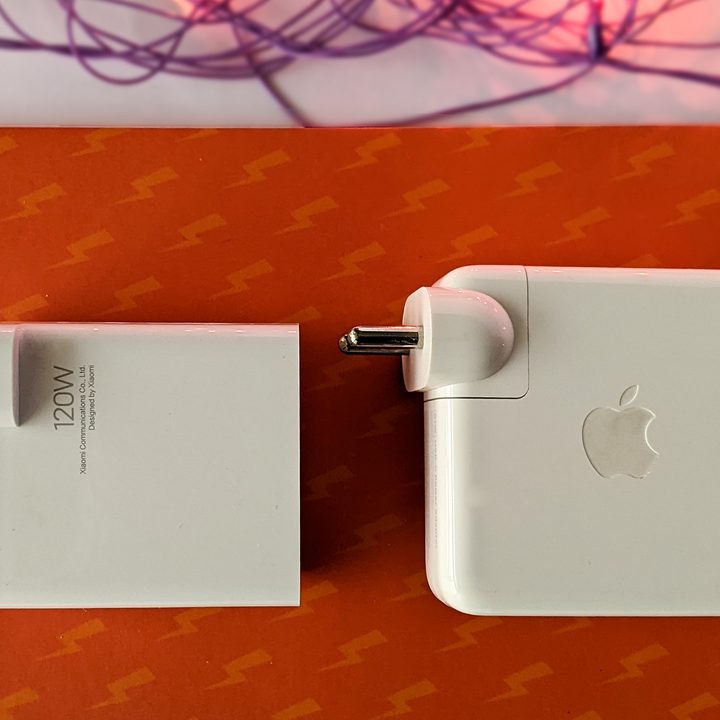 Size comparison between Xiaomi 120 watt hypercharge charger brick and Apple MacBook Pro 13-inch 61 watt charging brick