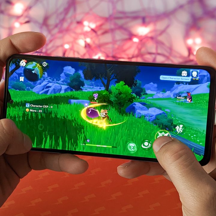 Xiaomi Mi 11i HyperCharge aka Redmi Note 11 Pro China variant with 120 watt fast charging against orange background with purple twinkle lights while playing Genshin Impact for Android.
