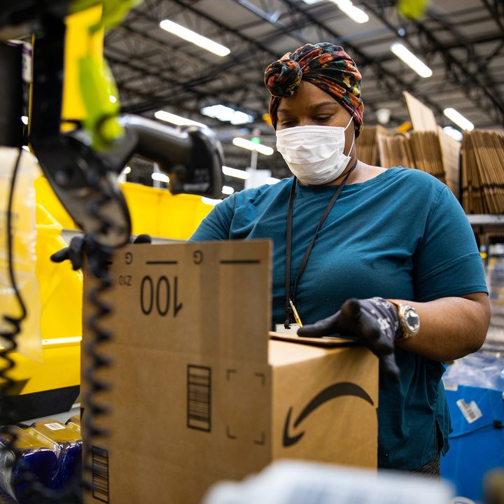 An Amazon worker boxes up products.