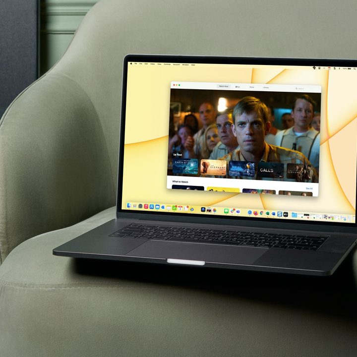 MacBook on a chair with the TV app on the screen.