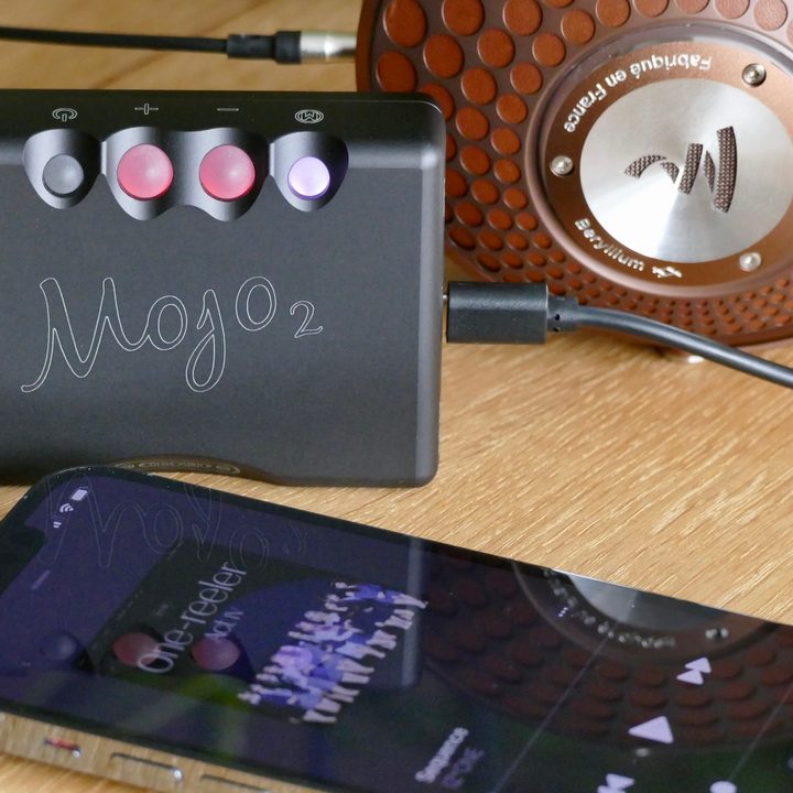 The Chord Mojo 2 with headphones and an iPhone 13 Pro.