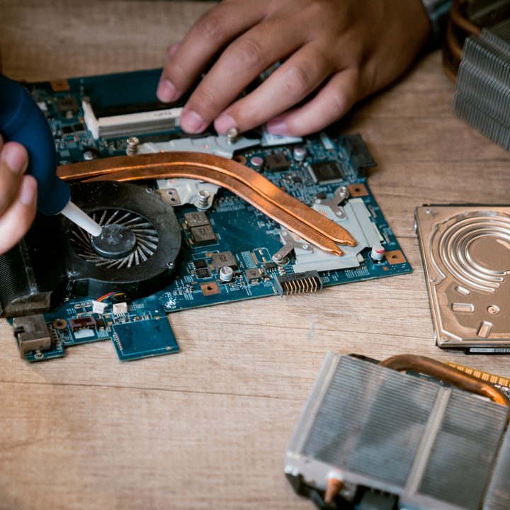Cleaning a laptop fan with air blower.