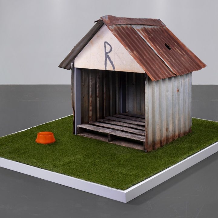 A doghouse with a hole in the roof caused by a meteorite.