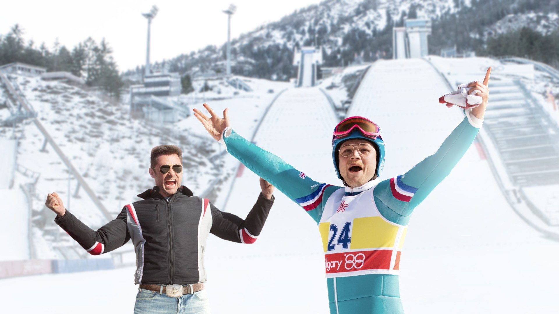 A skier celebrates with his coach outside in Eddie the Eagle.