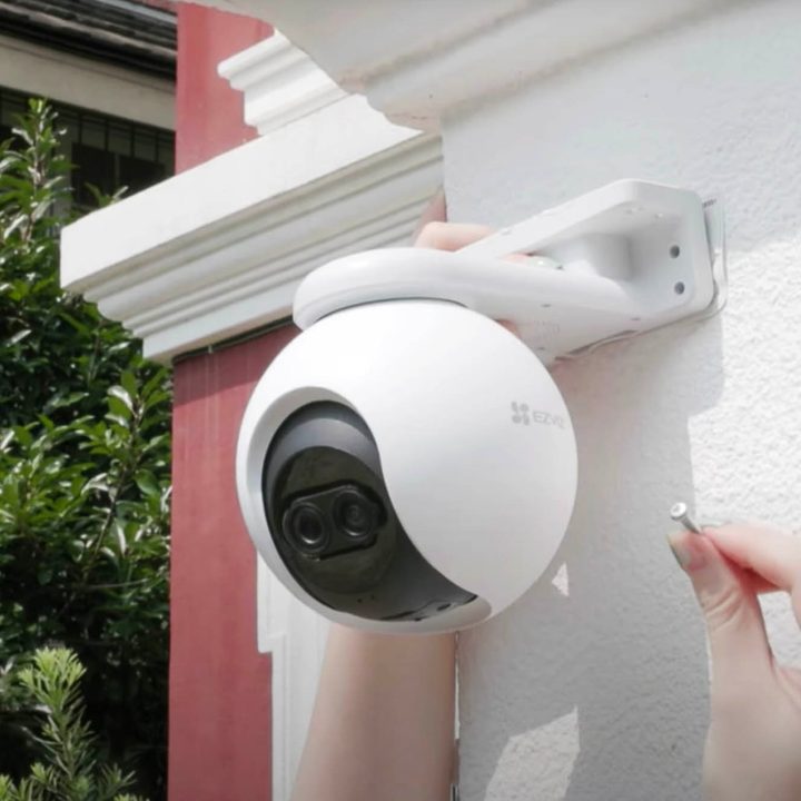 A EZVIZ C8PF being hung up outside a home.
