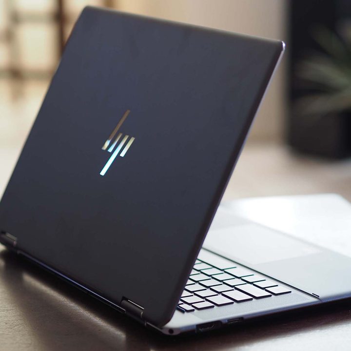 An open HP Spectre x360 16 sits on a table, angled so that the lid can be seen.