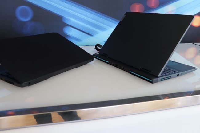 The rear of black 16-inch IdeaPad Gaming 3 open on the right next to the prior generation IdeaPad Gaming 3 open on the left.