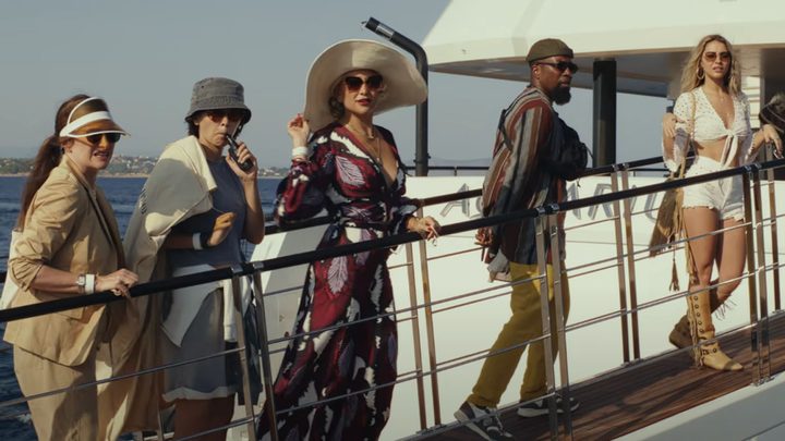 The cast of Knives Out 2 walks up the steps of a boat.